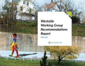 A mural of a girl in a rainbow dress on a wall in Pittsfield with a report title that reads 