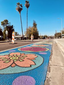A mural of colored flowers is painted on the sidewalks as part of the Adaptive Streets project on College Avenue in Tempe, Arizona. 